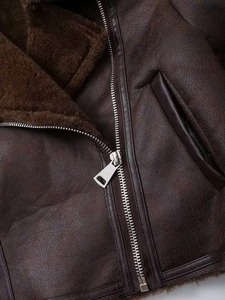 Detail of silver zipper and plush lining on vintage brown faux suede biker jacket