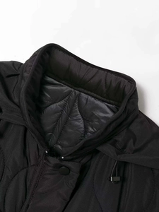 Detail of high collar and diamond quilting on a black winter puffer jacket with drawstring
