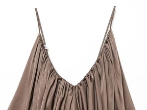 Detail of dark brown satin top featuring thin straps, deep V-neck, and delicate ruching