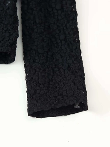 Close-up of black textured bubble lace fabric with intricate 3D floral embroidery patterns