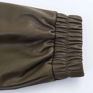Detailed view of elastic cuffs on a dark olive faux leather bomber jacket