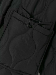 Detail of black wave quilted fabric with functional drawstring pocket on the winter coat