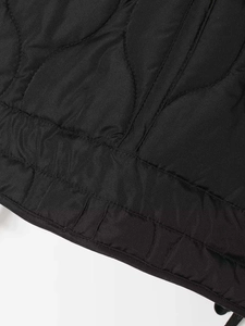 Close-up of black quilted fabric with wavy stitching on a winter jacket