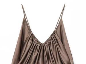 Detail of a brown satin camisole showing thin spaghetti straps and draped silky fabric