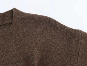 Dettaglio della maglia marrone scuro con trama ricca e sensazione di morbidezza