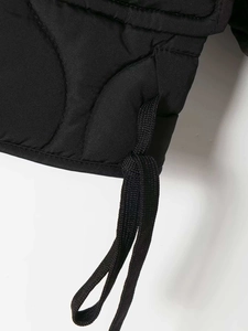 Close-up of black quilted jacket hem featuring adjustable drawstring and wave stitching