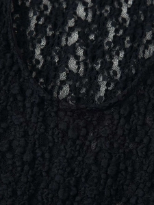 Macro shot of detailed black lace fabric with intricate floral patterns and cutout textures