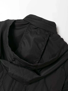 Detail of black quilted puffer jacket featuring stand collar and windproof polyester fabric