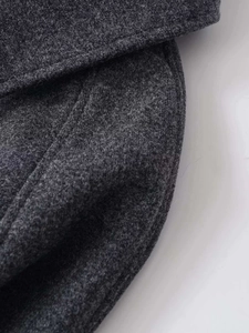 Vue macro du tissu en laine gris foncé montrant la texture épaisse et la finition