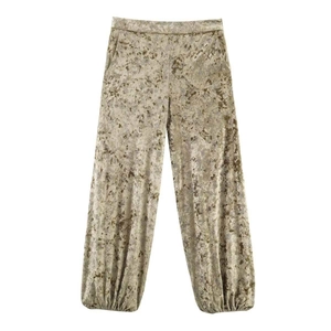 Detalle de los pantalones bombachos de terciopelo dorado con estampado floral