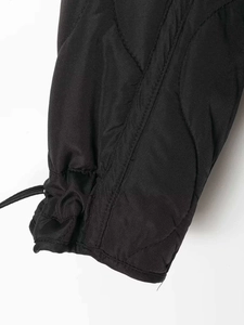 Detail of black quilted puffer jacket sleeve with adjustable elastic drawstring cuff