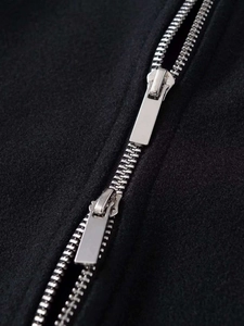 Close-up of premium silver double-ended metal zipper on a black wool blend jacket