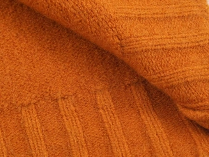 Close-up of knit jacket texture in burnt orange with ribbed vertical stripe pattern