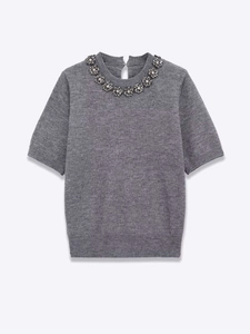 Close-up of grey knit top featuring sparkling rhinestone floral clusters on neckline