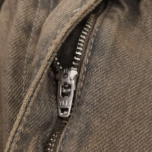 Detail of high-quality YKK brass zipper on high-waist loose fit wide-leg denim jeans