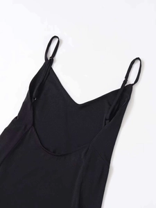 Detail of a black backless maxi dress featuring thin straps and a deep V-neckline