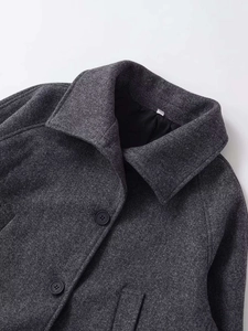 Détails de la veste en laine gris foncé avec col à revers et boutons en résine
