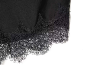 Dettaglio del bordo in pizzo nero sul morbido scialle in raso nero da donna