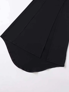 Detail view of the black dress featuring a high-low asymmetrical hem and knitted fabric