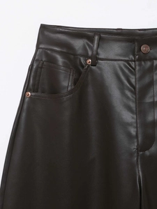 Dettaglio dei pantaloni in ecopelle marrone scuro con cuciture e bottone in metallo