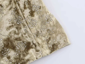 Detalle de tela de terciopelo con estampados de rosas brillantes y textura reluciente