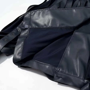 Detail of black leather jacket showing fine stitching and metallic silver buttons