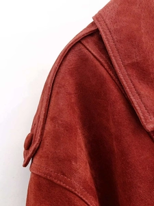 Detail view of brick red faux suede jacket featuring epaulettes and notch lapels