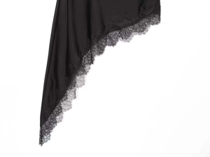 Dettaglio dell'orlo nero asimmetrico con pizzo floreale delicato e tessuto liscio e fluido