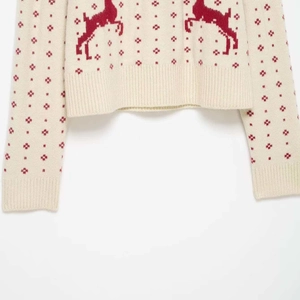 Winter knit sweater with red reindeer and snowflake jacquard patterns on cream white fabric