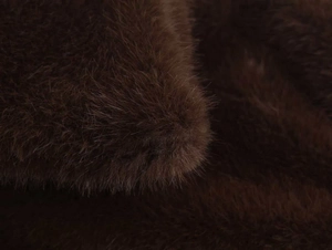 Detail shot of the deep brown faux fur texture and dense fibers on the lapel jacket