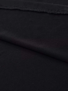 Close-up of black textile fabric with fine grain texture and professional hem stitching