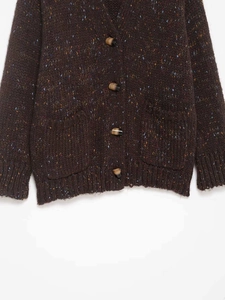 Détail d'un cardigan en maille marron foncé avec mouchetures colorées et boutons en corne