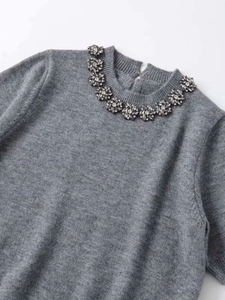 Close-up of grey knit top neckline with elegant rhinestone and crystal floral beading