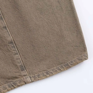 Macro shot of brown twill cotton fabric with uniform stitching and frayed hem detail