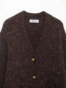 Détail d'un cardigan en maille marron foncé avec boutons à bascule et décolleté en V