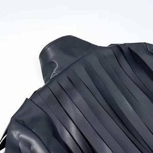 Detail shot of the back of a black leather jacket featuring long flowing fringe tassels