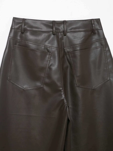 Dettaglio dei pantaloni in ecopelle marrone scuro con tasche posteriori e trama opaca