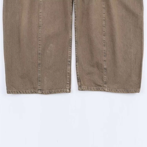 Detail of high-waist wide-leg jeans showing washed brown denim hem and twill texture