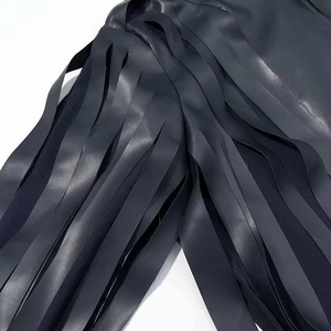 Detailed macro view of high-quality navy faux leather fringe on a stylish jacket