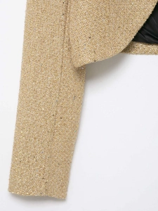 Gros plan détaillé de la manche en tweed avec fils métalliques et doublure noire lisse