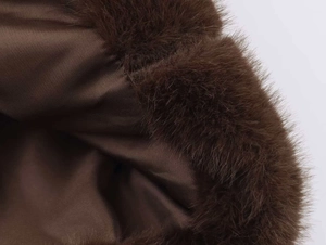 Macro shot of deep brown faux fur jacket lining and fine stitching on satin fabric