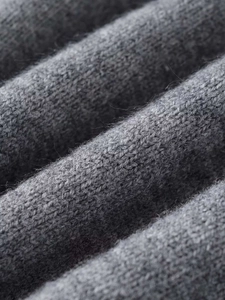 Close-up of grey knit fabric showing soft texture and detailed beaded crewneck stitching