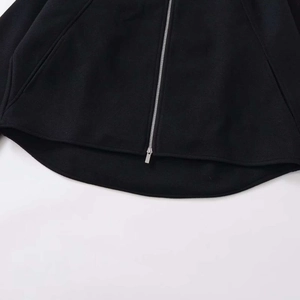 Women's black loose zip-up wool jacket with metallic zipper detail and hem view