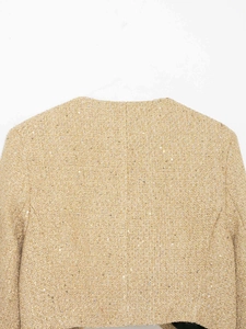 Vue détaillée de la texture du tissu en tweed doré avec des paillettes brillantes