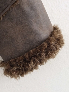 Detail of faux suede jacket with plush brown faux fur lining and vintage texture