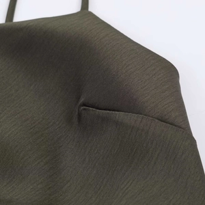 Detail view showing deep olive green satin fabric with delicate lace and stitching