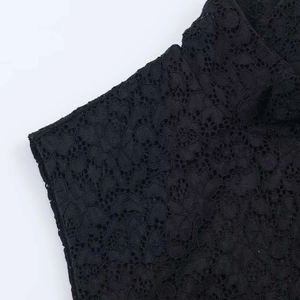 Close-up of black floral lace fabric with intricate crochet patterns and mesh details
