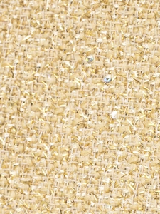 Vue macro du tissu en tweed doré métallisé avec des sequins scintillants et une texture riche