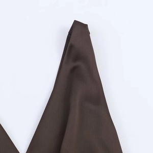 Dettaglio dello scollo dell'abito midi in raso color cioccolato con cuciture piatte rifinite