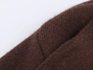 Gros plan détaillé de la texture du tricot marron foncé montrant les fibres du tissu épais